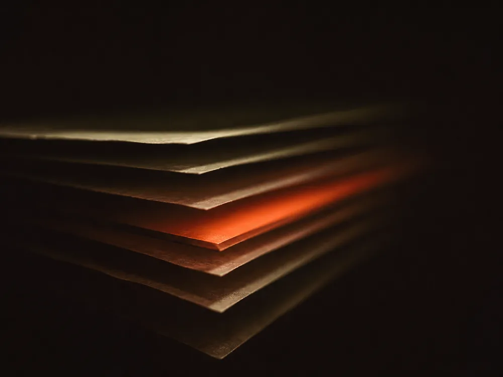 A stack of thin translucent layers seen at a low angle, one of them glowing hot in the middle of the stack.
